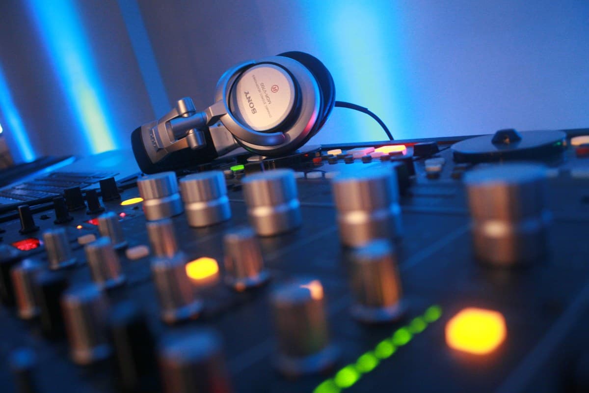 Headphones resting on a lit DJ mixer