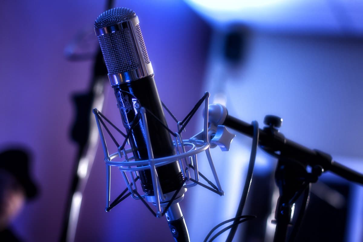 A condenser microphone in a shock mount under blue light
