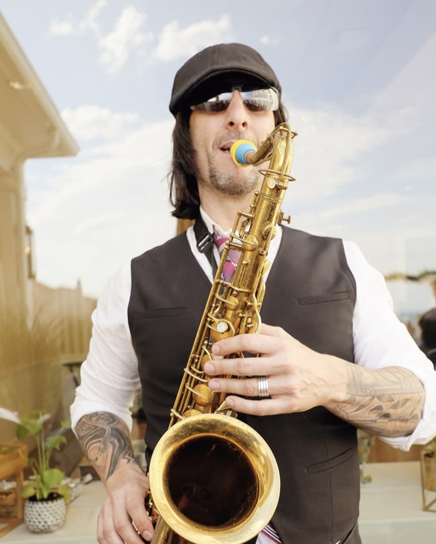 Greg Capozzi playing tenor sax at an outdoor corporate event