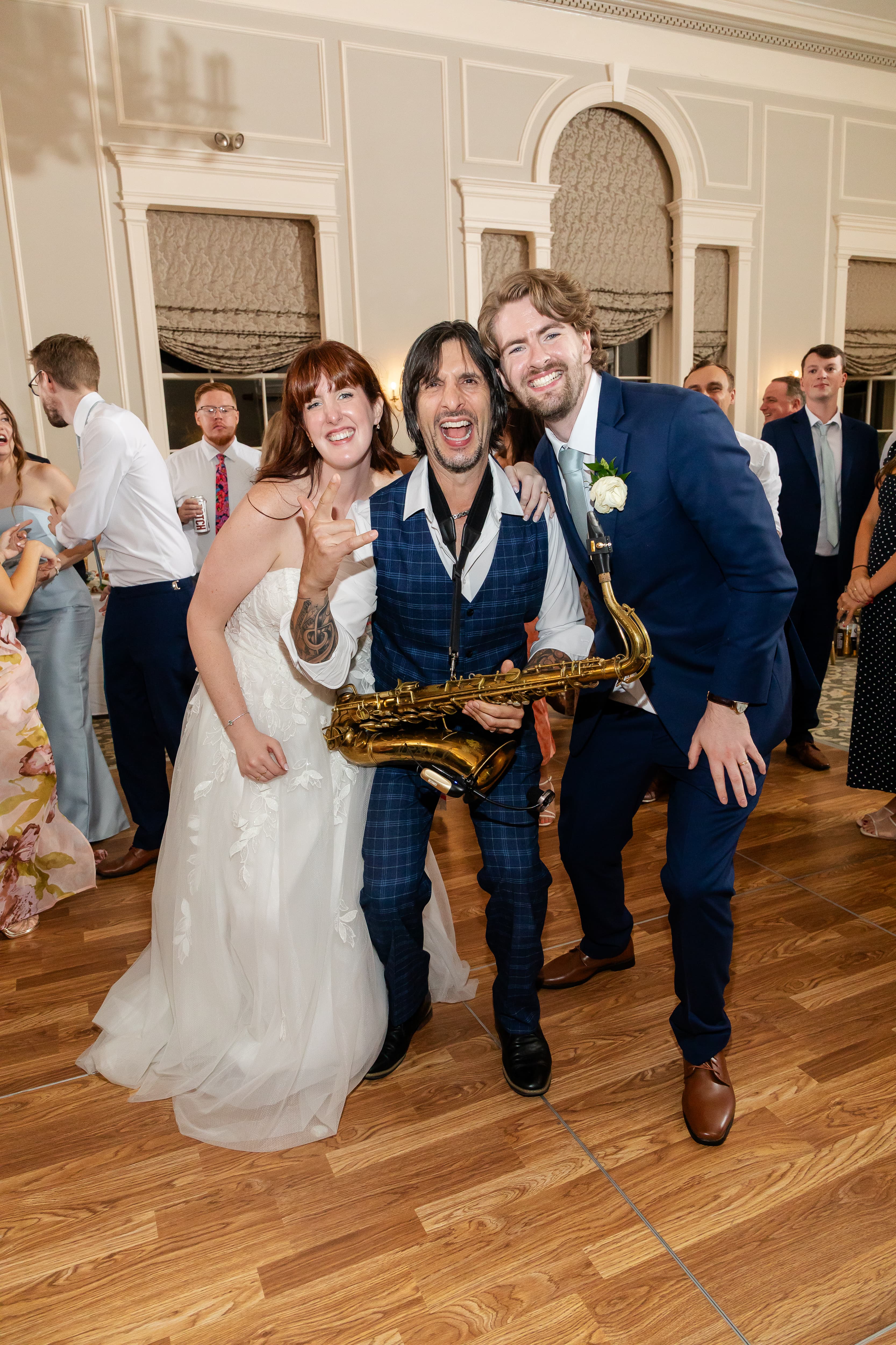 Sax player celebrating with newlyweds on the dance floor