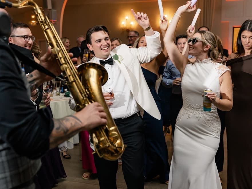 Sax player in the crowd beside the newlyweds during the dance set