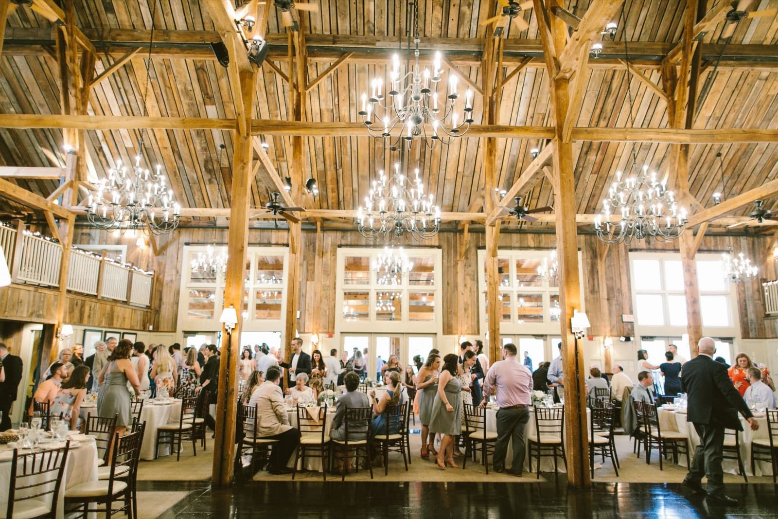 The Barn at Gibbet Hill set for dinner under its timber beams and chandeliers, without uplighting