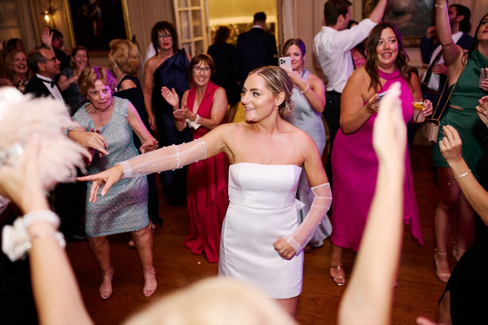 The bride dancing with her guests on a packed floor in the Crane Estate ballroom