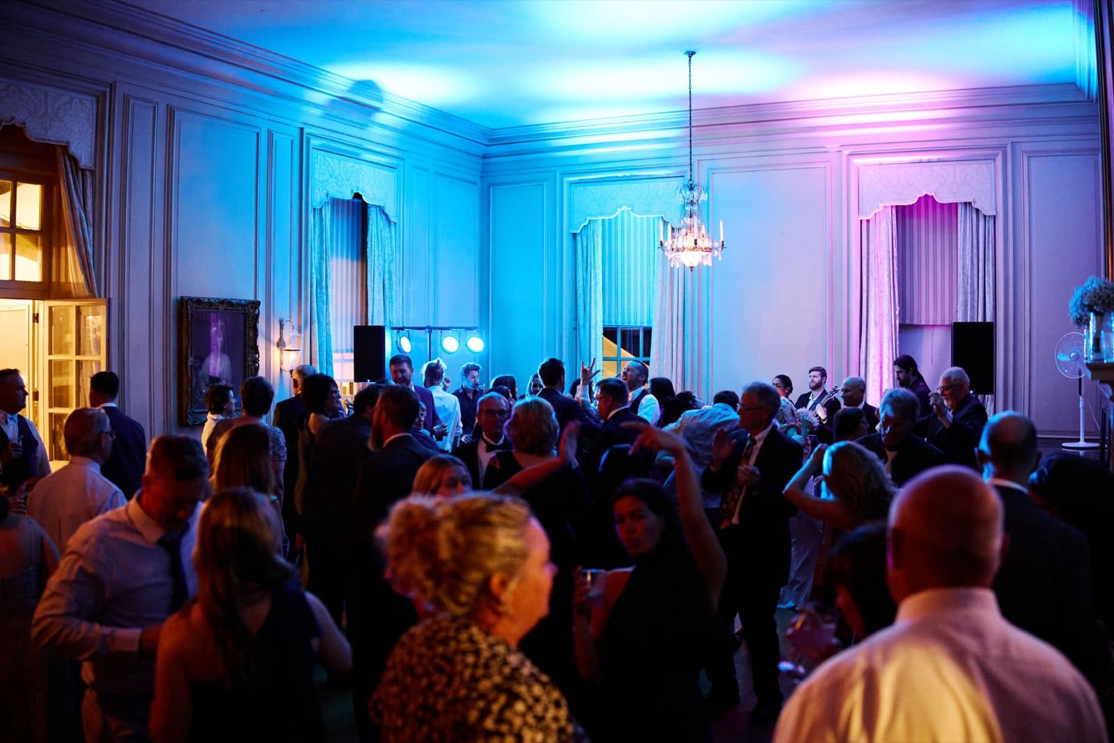 The Crane Estate ballroom in blue and pink uplighting, guests filling the dance floor