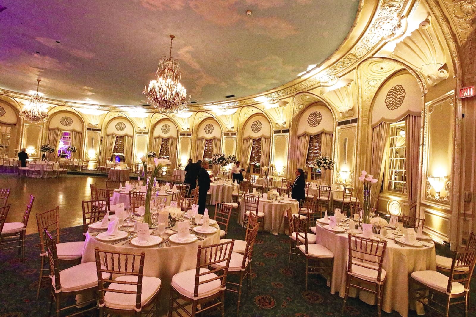 The Oval Room at the Fairmont Copley Plaza set for dinner, its gold walls washed in soft white uplighting