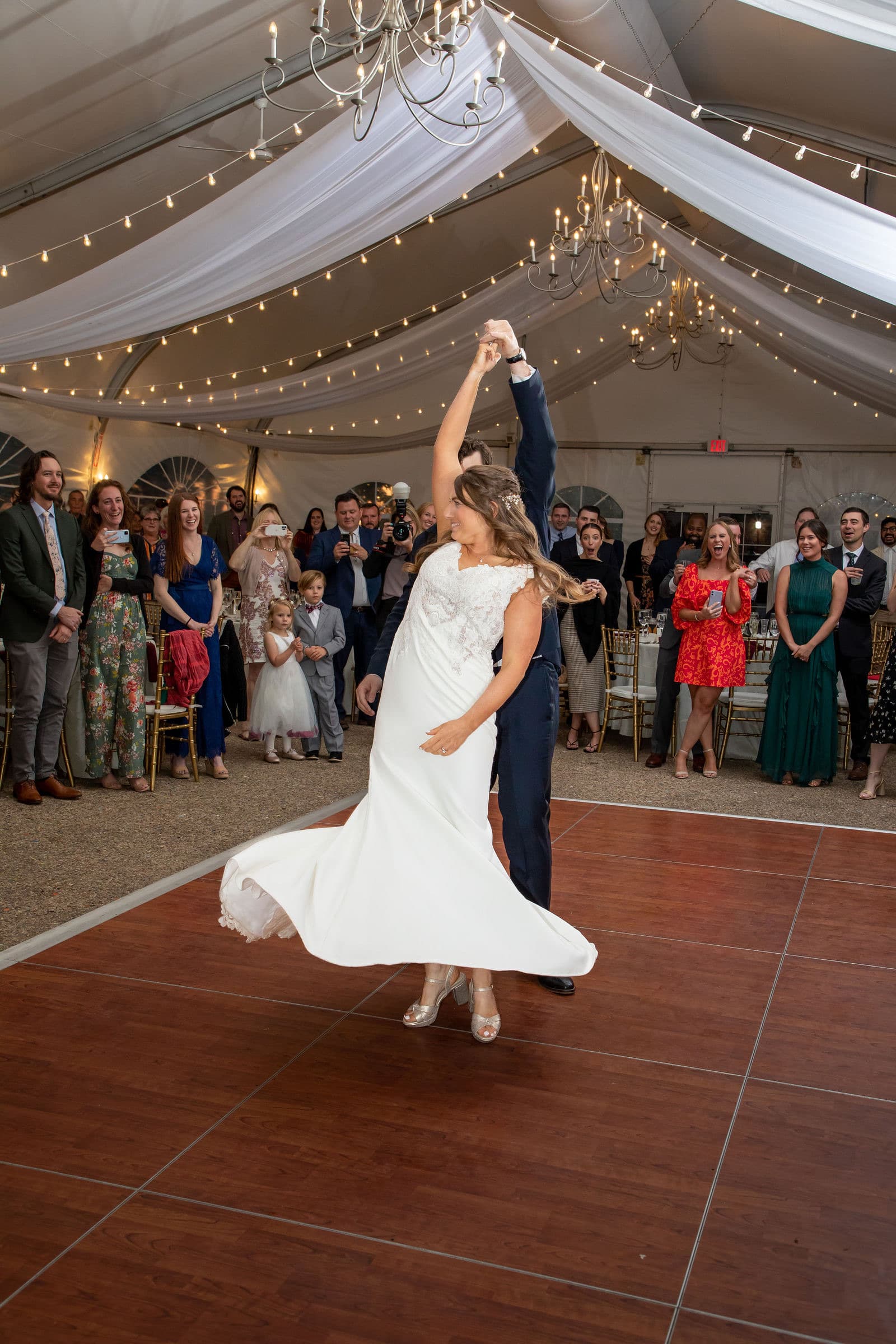 A bride spinning on the dance floor in the Misselwood tent with guests circling her