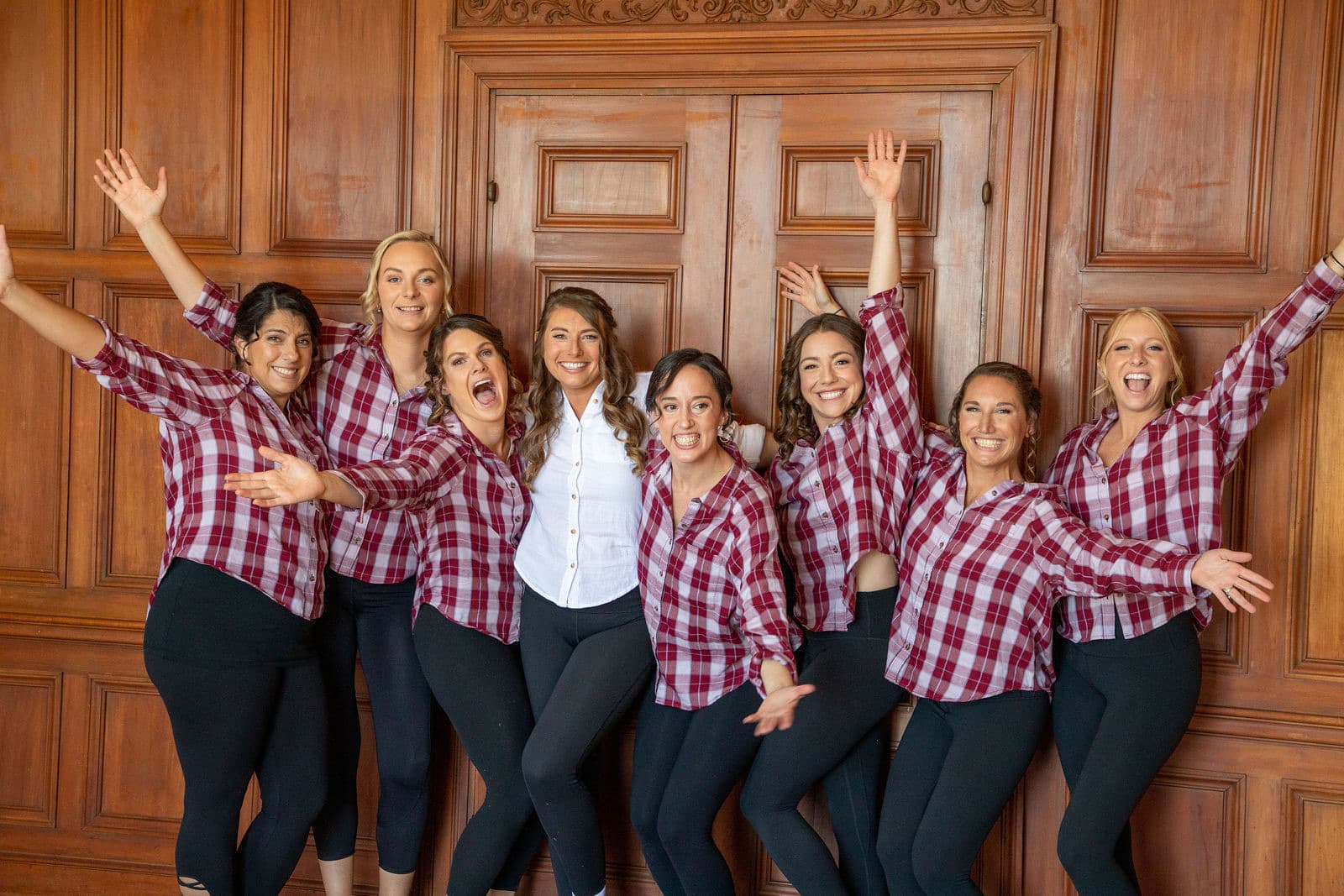 A wedding party in matching shirts in the wood-panelled room inside the Misselwood mansion