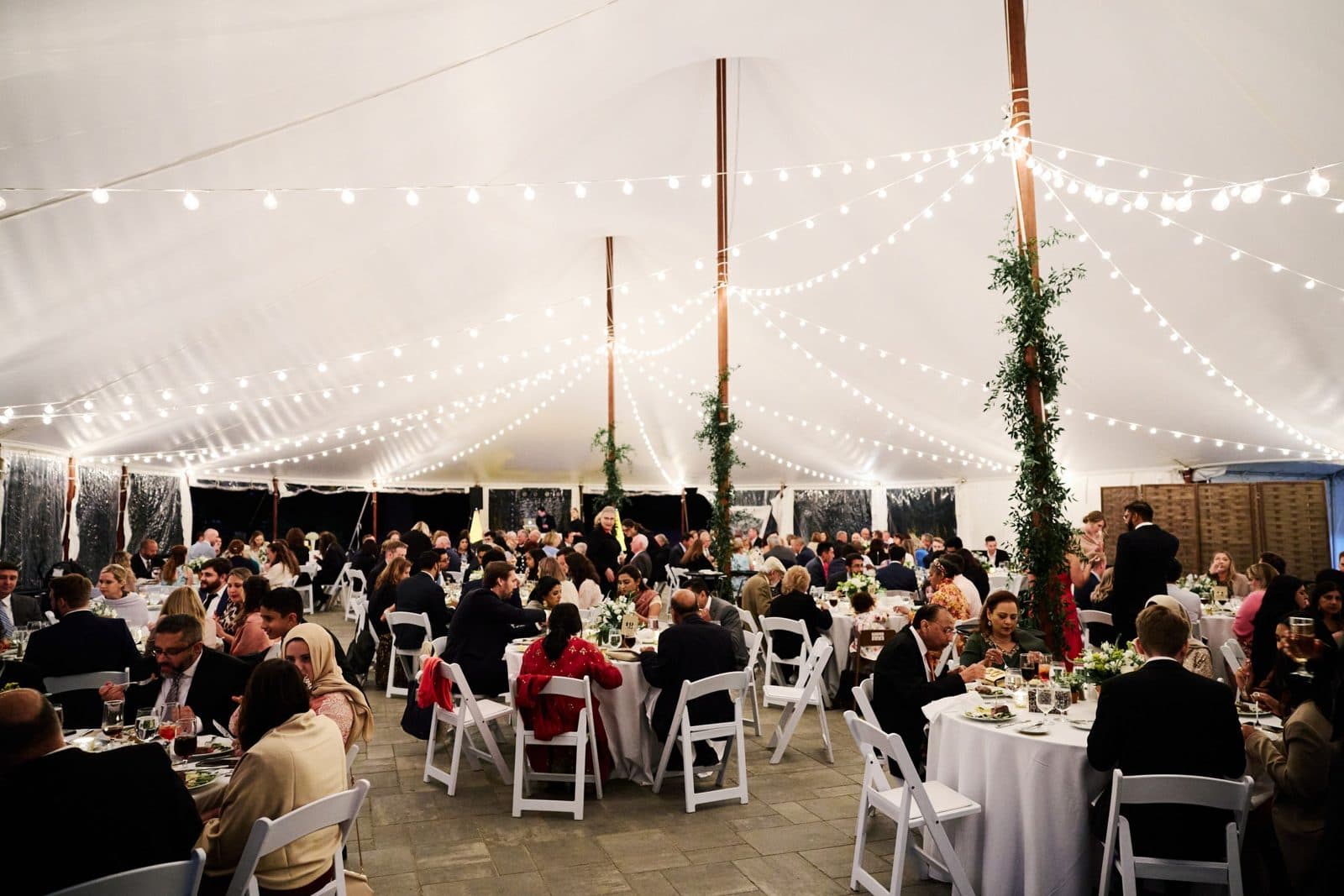 The tent at Moraine Farm set for dinner under string lights, without uplighting
