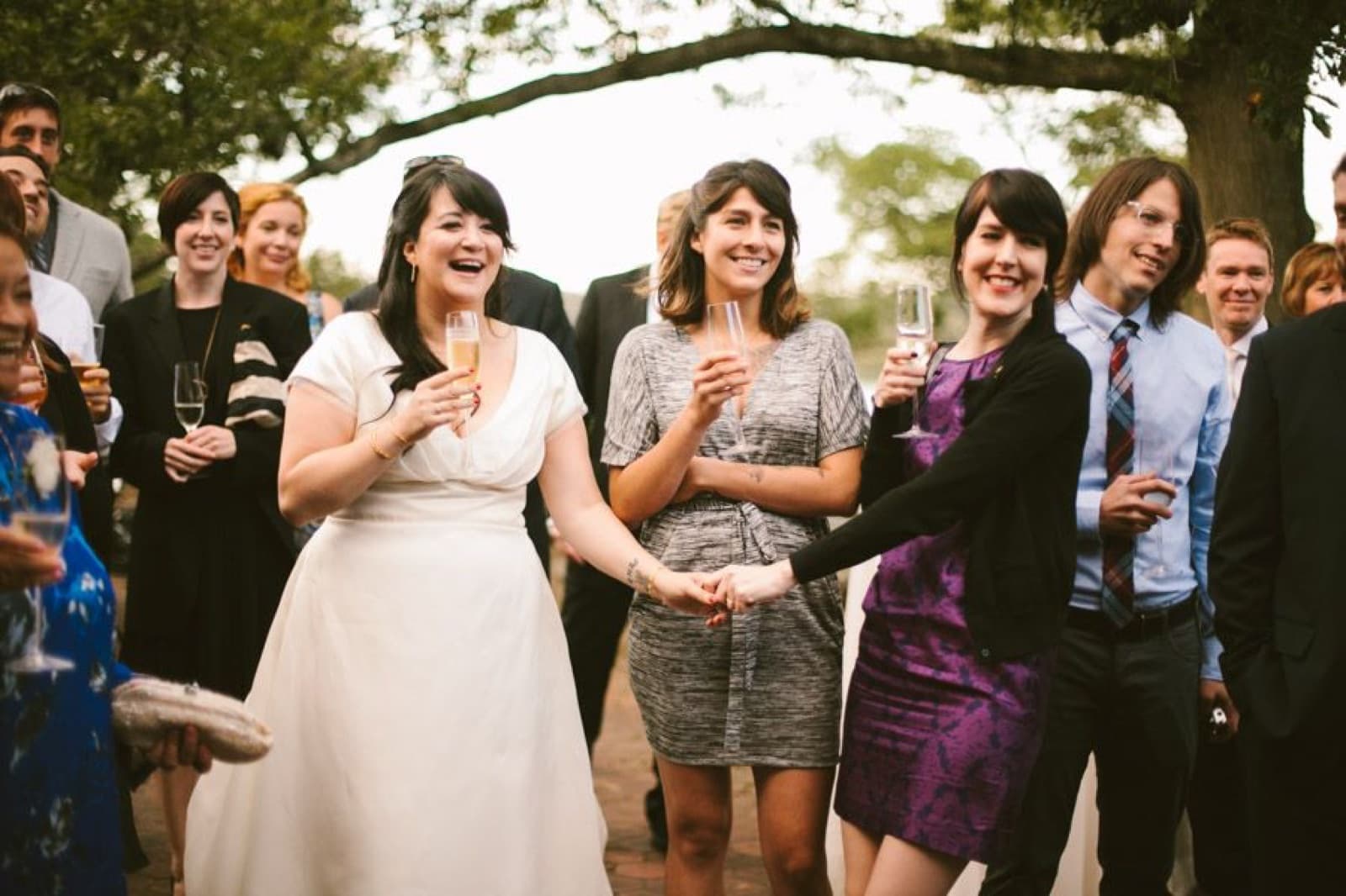 Wedding guests raising champagne glasses during cocktail hour at Moraine Farm