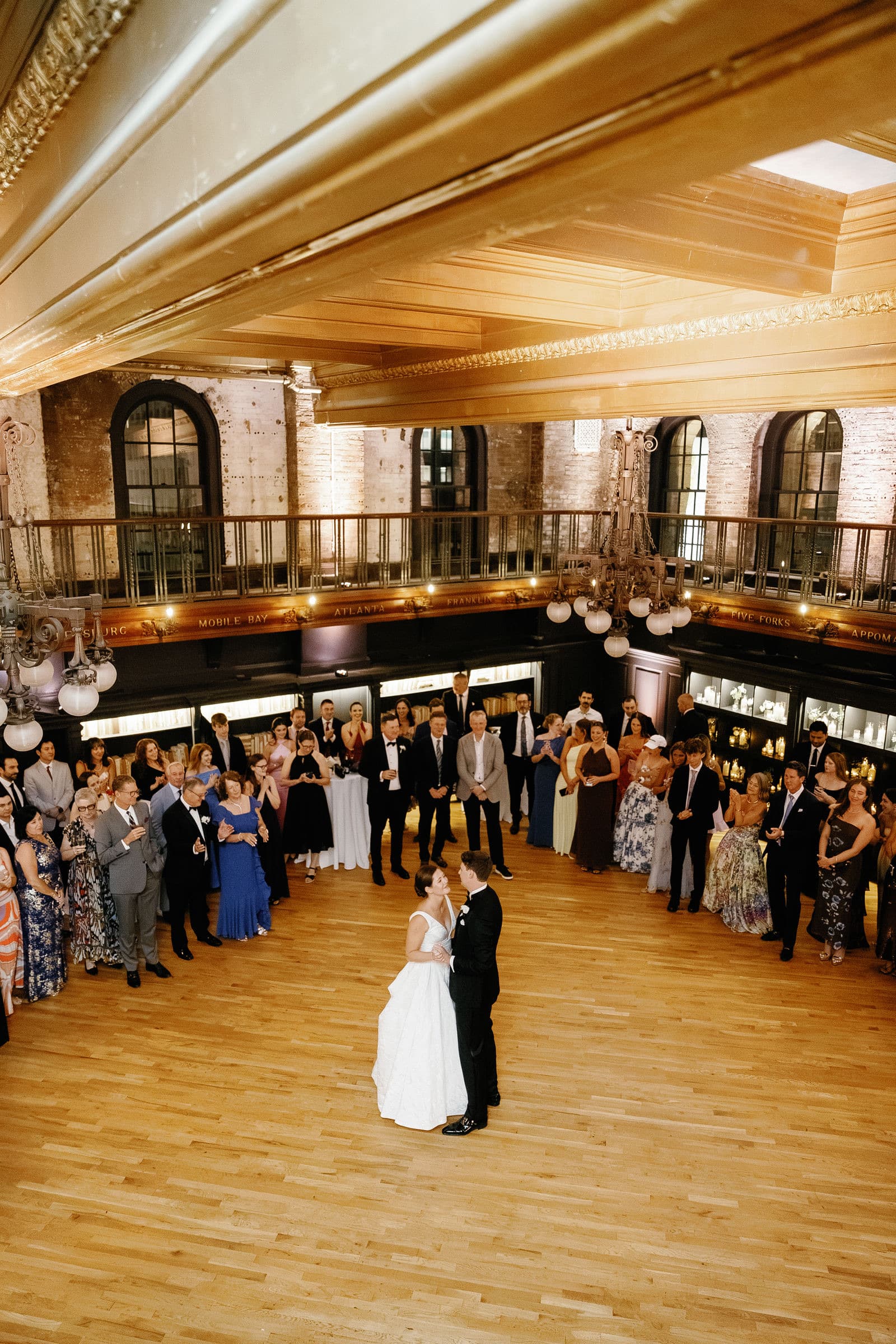 The first dance at The Tower seen from the balcony, the couple alone on the floor and guests around the edge