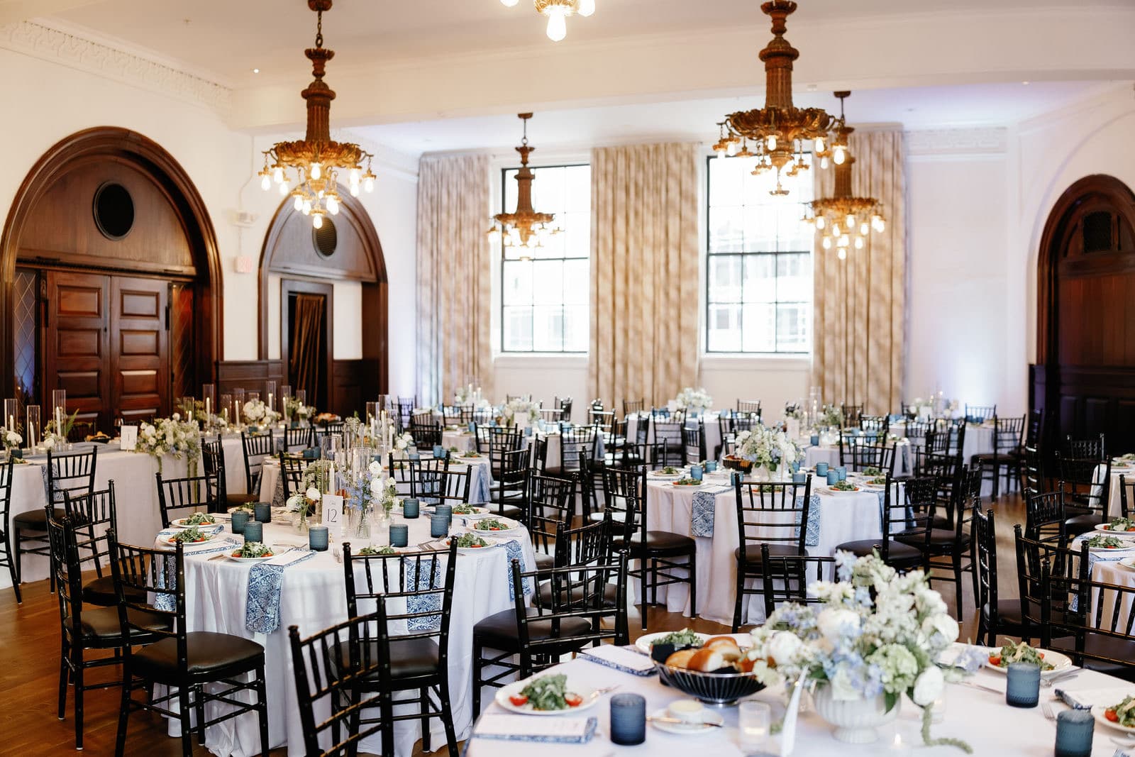 The dinner room at The Tower set with round tables and uplighting on the walls