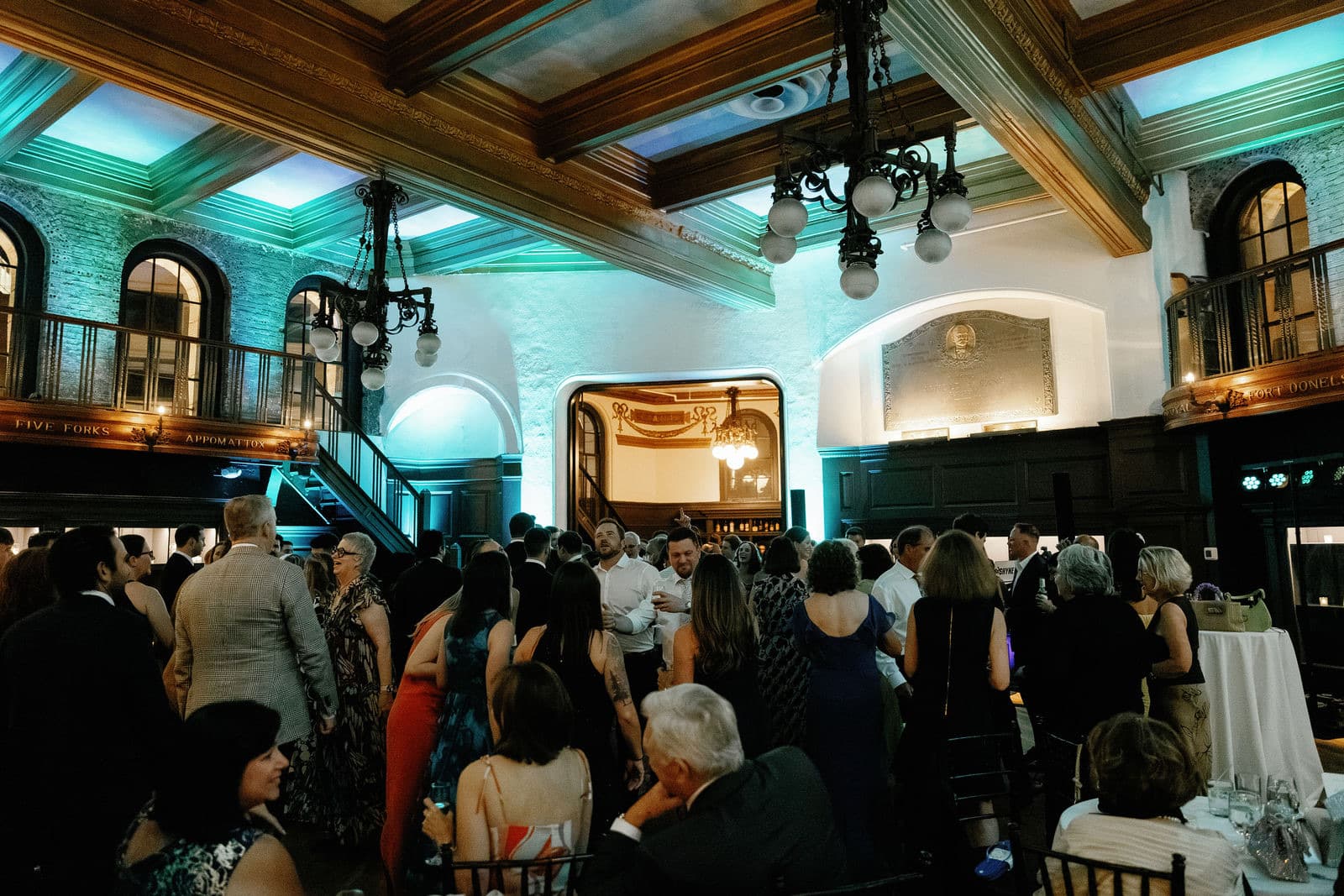 The main hall of The Tower during the dance set, wooden beams overhead and teal uplighting on the balcony walls