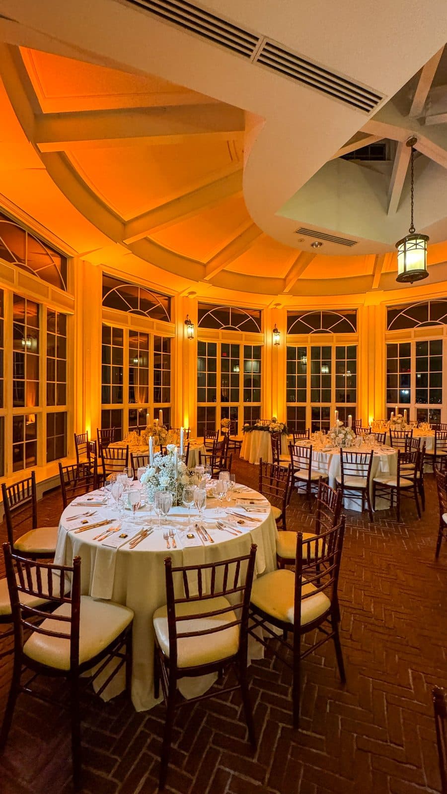 The Tupper Manor conservatory in amber uplighting for dinner
