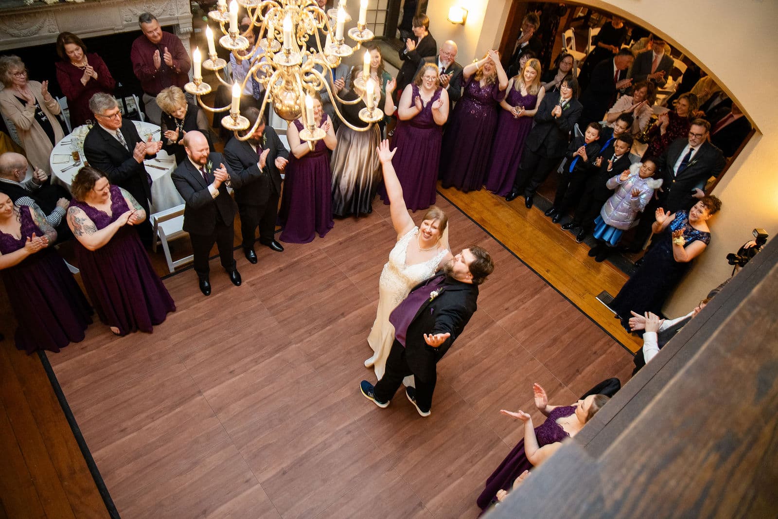 A first dance in the Willowdale Estate Great Room seen from the loft, guests ringing the floor