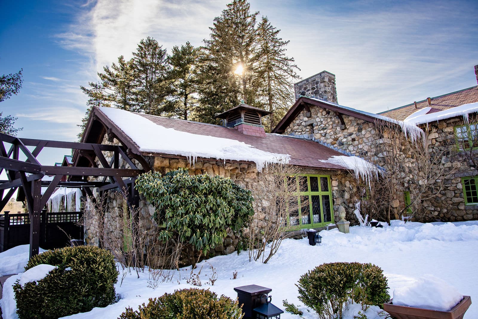The garden side of the Willowdale Estate mansion with the pergola, stone walls and evergreens