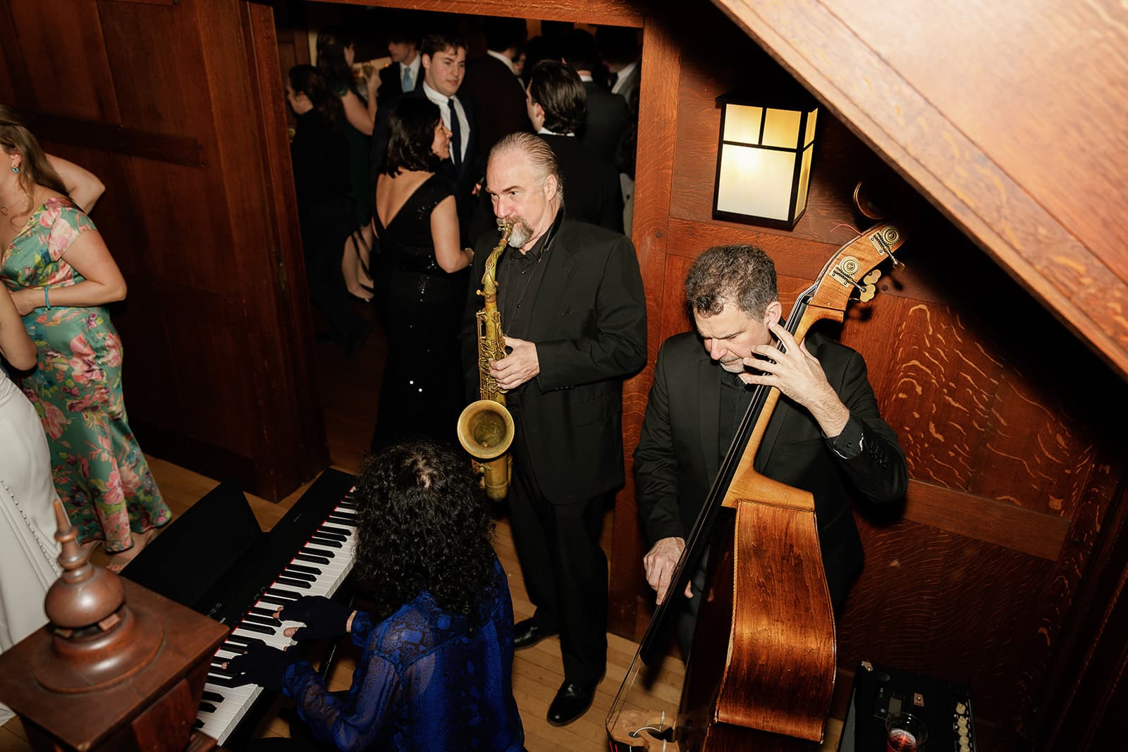 C-Zone's sax, keyboard and upright bass trio playing at the foot of the wooden staircase at Willowdale Estate