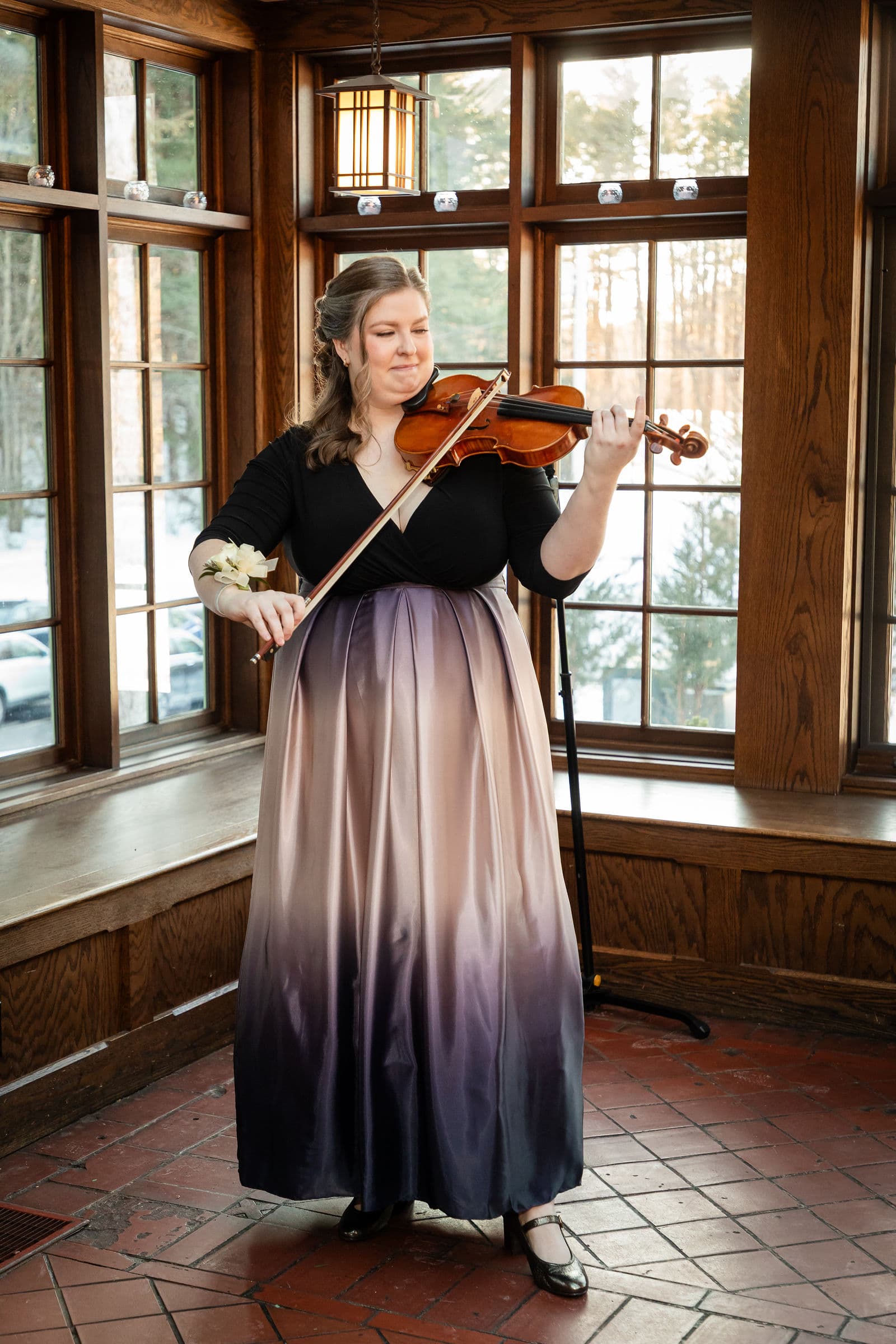 A violinist playing by the windows of the Willowdale Estate conservatory before a ceremony