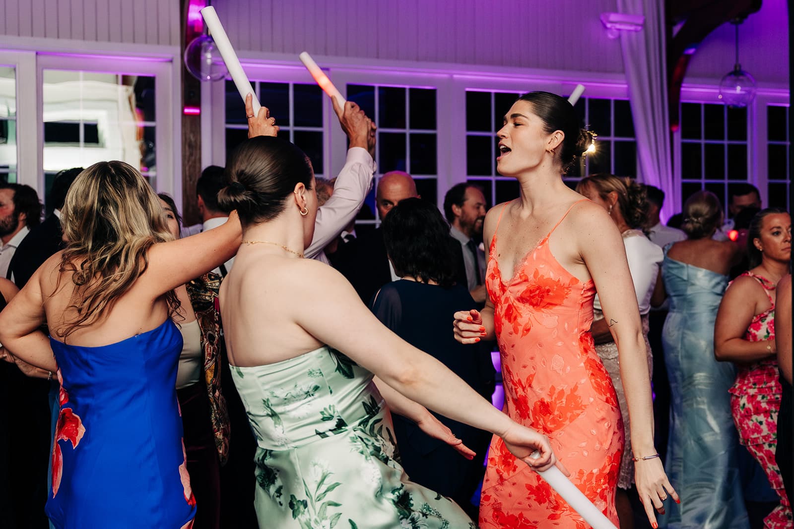 Guests dancing in the Harbor Room at Wychmere Beach Club under purple uplighting